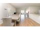 Open-concept dining area with a large table, hardwood floors, and seamless flow to the living and kitchen spaces at 723 Joywood Dr., Longs, SC 29568