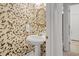 Stylish powder room featuring floral wallpaper, pedestal sink, and decorative mirror at 75 Haig Ct., Georgetown, SC 29440