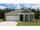 Charming single-story home with green siding, white trim, a two-car garage, and manicured landscaping at 8072 Bear Claw Way, Conway, SC 29526