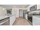 Modern kitchen with stainless steel appliances, granite countertops, white cabinets, and wood-look flooring at 8072 Bear Claw Ct., Conway, SC 29526