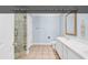 Spacious bathroom with double vanity, a tiled shower, and light blue walls at 885 S Waccamaw Dr., Garden City Beach, SC 29576