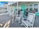 Spacious porch features rocking chairs and outdoor seating, perfect for relaxing and enjoying coastal breezes at 885 S Waccamaw Dr., Garden City Beach, SC 29576