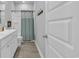 Bright bathroom featuring a white vanity, toilet, and shower with a blue curtain at 892 Harrison Mill St., Myrtle Beach, SC 29579