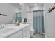 Bright bathroom featuring a white vanity, toilet, and shower with a blue curtain at 892 Harrison Mill St., Myrtle Beach, SC 29579