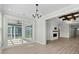 Open-concept living room with a fireplace, light wood floors, chandelier, and view to screened porch at 9035 Binnicker Dr., Murrells Inlet, SC 29576