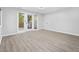 This empty bedroom features wood floors, white walls, and a set of glass paneled french doors at 954 Oakwood Ln., Myrtle Beach, SC 29572