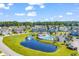 Aerial view of community with a pool, lake with fountain, well-manicured lawns and mature trees at 1018 Red Sky Ln. # 101, Murrells Inlet, SC 29576