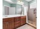 Bathroom featuring double sinks, wood cabinetry, and a walk-in shower with tiled walls at 1018 Red Sky Ln. # 101, Murrells Inlet, SC 29576