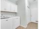 Functional laundry area featuring a washer, dryer, white cabinets and tile flooring at 1018 Red Sky Ln. # 101, Murrells Inlet, SC 29576