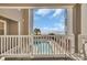 Scenic balcony view of a community pool, palm trees, and the ocean at 1113 N Ocean Blvd. # 101, Surfside Beach, SC 29575