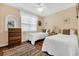 Cozy bedroom with two twin beds, a ceiling fan, hardwood floors, and natural light at 1113 N Ocean Blvd. # 101, Surfside Beach, SC 29575