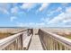 Wooden boardwalk with railings leads to the beach, offering ocean views at 1113 N Ocean Blvd. # 101, Surfside Beach, SC 29575