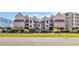 Exterior view of the condo complex featuring raised construction with a lush landscaped yard at 1113 N Ocean Blvd. # 101, Surfside Beach, SC 29575