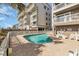 Exterior view of a clear community pool with lounge chairs, residential buildings with balconies, and white picket fence at 1113 N Ocean Blvd. # 101, Surfside Beach, SC 29575