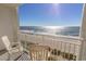 Sunny balcony view of beach with ocean waves and sky, with white chairs at 1205 S Ocean Blvd. # 20409, Myrtle Beach, SC 29577