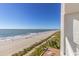 An elevated beach view from a balcony shows a sandy beach, blue water and clear skies at 1205 S Ocean Blvd. # 20409, Myrtle Beach, SC 29577