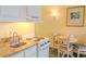 Practical kitchenette featuring a stove, sink, and dining table at 1205 S Ocean Blvd. # 20409, Myrtle Beach, SC 29577