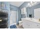 Blue-walled bathroom featuring a shower, toilet, vanity with a large mirror, and white cabinets at 131 Waypoint Ridge Ave. # Q29, Little River, SC 29566