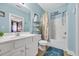 Light blue bathroom with white vanity, shower and shelving unit holding towels and seashell decorations at 131 Waypoint Ridge Ave. # Q29, Little River, SC 29566