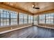 A sunroom features walls of windows, wood plank ceiling and dark wood-look floors at 1525 Sunmeadow Dr., Conway, SC 29526