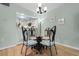 Dining area with glass-top table, unique chairs, and a view to the kitchen at 180 Rothbury Circle # 302, Myrtle Beach, SC 29572