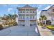 Charming coastal home featuring double porches, a light blue exterior, and a spacious driveway at 186 Cayman Loop, Pawleys Island, SC 29585