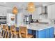 Bright kitchen features a large island with bar seating, stainless appliances, and rattan pendant lights at 186 Cayman Loop, Pawleys Island, SC 29585