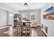 Bright living room featuring hardwood floors, neutral paint, decorative lighting, tv, sofa, and pub table with seating at 186 Cayman Loop, Pawleys Island, SC 29585