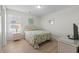 Cozy bedroom features a bright, quilted bedspread, side table with lamp, and decorative wall art at 2000 N Waccamaw Dr., Garden City Beach, SC 29576