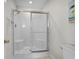 Step-in shower with frameless glass doors and a built-in bench in a naturally lit bathroom at 2000 N Waccamaw Dr., Garden City Beach, SC 29576