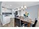 Dining area with a marble-top table, sleek black chairs, and kitchen featuring stainless appliances at 206 Balsa Dr., Longs, SC 29568