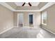 Large main bedroom with plush carpet, ceiling fan, and doorways to ensuite bathroom and walk-in closet at 206 Balsa Dr., Longs, SC 29568
