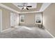 Bright main bedroom with tray ceiling, plush carpet, ceiling fan, and two windows at 206 Balsa Dr., Longs, SC 29568