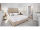 Bright bedroom with a tufted headboard, side tables, and a doorway leading to the ensuite bathroom at 267 Warner Crossing Way, Loris, SC 29569