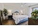 Bright bedroom featuring a comfortable bed, wood floors, natural light, and a decorative mirror and plants at 298 Pinehurst Ln. # 10-J, Pawleys Island, SC 29585