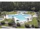 A large community pool surrounded by lounge chairs, umbrellas, and lush landscaping for outdoor enjoyment at 298 Pinehurst Ln. # 10-J, Pawleys Island, SC 29585