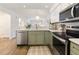 Open concept kitchen with stainless steel appliances, green cabinets, and view to the living area at 298 Pinehurst Ln. # 10-J, Pawleys Island, SC 29585