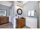Bathroom showcasing a circular mirror above a vintage wooden sink cabinet and new wood-look floors at 309 W Bond St., Marion, SC 29571