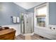 Bathroom with a glass corner shower, vintage sink cabinet, wood-look flooring, white wainscoting and a window at 309 W Bond St., Marion, SC 29571