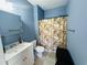 Bathroom with blue walls, modern vanity, and a shower with dog-themed curtain at 330 Kiskadee Loop # A, Conway, SC 29526