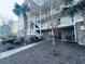 Inviting condo exterior with palm trees, white stairs, a walkway, and brick accents at 330 Kiskadee Loop # A, Conway, SC 29526