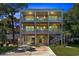 Gorgeous three-story beach house with illuminated balconies and covered parking, showcasing its elegance at twilight at 3304 Palm St., North Myrtle Beach, SC 29582