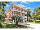 Vibrant three-story coastal home with a bright exterior, multiple balconies, and lush tropical landscaping in a sunny setting at 3304 Palm St., North Myrtle Beach, SC 29582