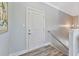 Hallway with hardwood floors leads to a white door and a staircase with a metal handrail at 3304 Palm St., North Myrtle Beach, SC 29582