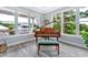 Living room with hardwood floors features a piano next to multiple windows with green outdoor views at 3304 Palm St., North Myrtle Beach, SC 29582