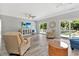 Bright living room features lots of seating, a television, ceiling fan, and access to a deck through sliding glass doors at 3304 Palm St., North Myrtle Beach, SC 29582