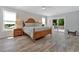 Sunlit main bedroom featuring a king bed, sliding glass doors to a balcony, and stylish wood-look floors at 3304 Palm St., North Myrtle Beach, SC 29582