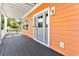 Charming front porch with gray flooring, showcasing an inviting entrance with transom windows and warm lighting at 3304 Palm St., North Myrtle Beach, SC 29582