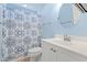 Bathroom with blue walls, a decorative shower curtain, a round mirror, and white sink vanity at 3516 Queens Harbour Blvd., Myrtle Beach, SC 29588