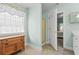 Bathroom featuring tile floors, a shower, a window providing natural light, and white cabinets at 3516 Queens Harbour Blvd., Myrtle Beach, SC 29588